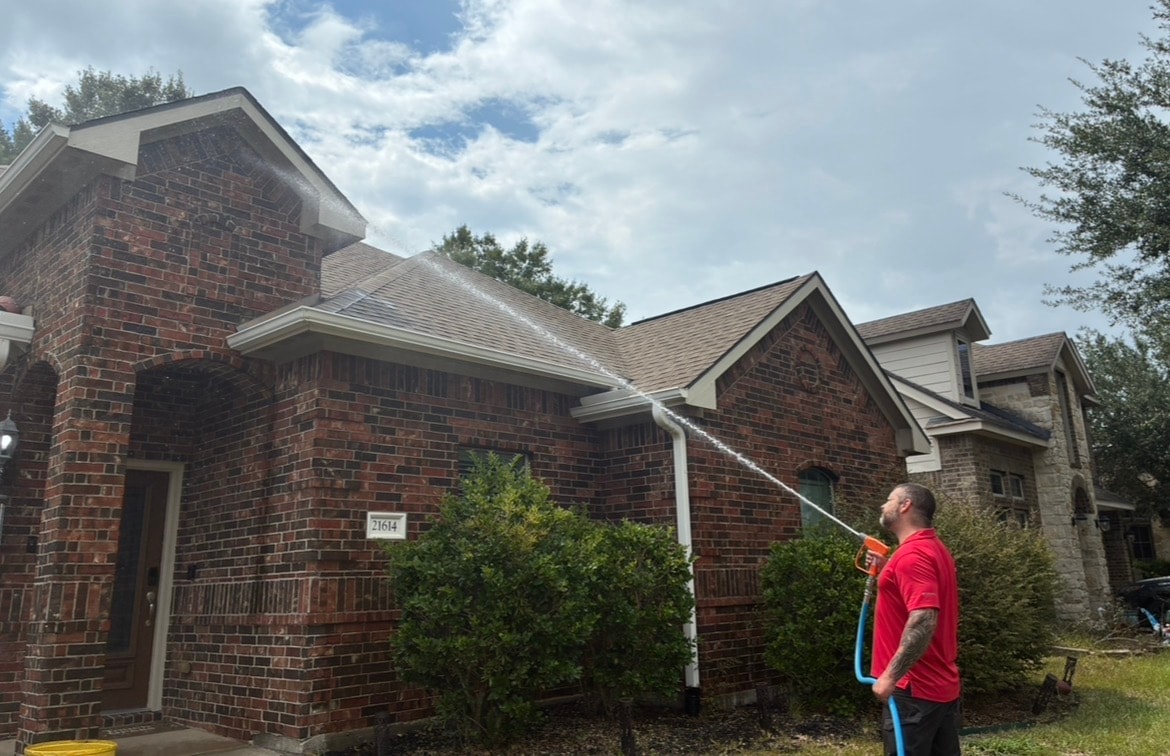 Elite Cleaning HTX technician washing a brick home exterior